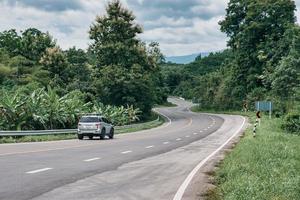 Autofahren auf kurvenreicher Straße auf dem Gipfel des Berges im tropischen Regenwald in der Provinz Nan foto