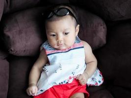 Baby asiatische Mädchen verkleiden sich in niedlichen Modekleidern für Neugeborene foto