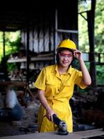 Eine Frau in Uniform, die in einem Techniker arbeitet, bereitet sich auf die Verwendung der Werkzeuge vor foto