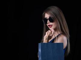 eine schöne asiatische frau in einem blauen kleid freut sich nach dem einkaufen foto