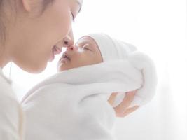 eine schöne asiatin trug ihr neugeborenes baby und küsste vor glück foto