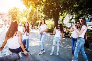 Wunderschöne junge Mädchen, die an einem sonnigen Tag Fotos auf dem Treet machen.