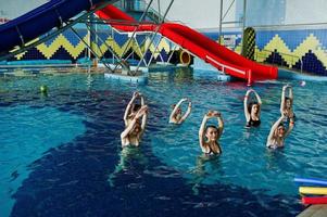 fitnessgruppe von mädchen, die aerobische übungen im schwimmbad im aquapark machen. Sport- und Freizeitaktivitäten. foto