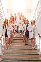 Gruppe junger Ärzte in weißen Kitteln, die im Krankenhaus posieren. foto