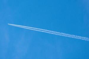 Kondensstreifen hinter einem Flugzeug Jet Liner an einem Tag mit strahlend blauem Himmel foto
