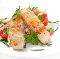 gebratenes Fischfilet und Salat aus frischem Gemüse foto