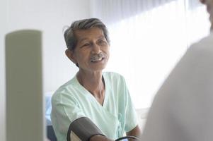 asiatischer älterer männlicher patient berät und besucht arzt im krankenhaus.. foto