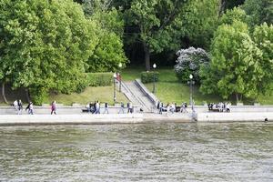 menschen gehen am damm entlang des moskauer flusses entlang. foto