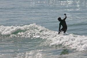 Surfer am Sonnenstrand foto