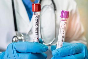 positive blutinfektionsprobe im reagenzglas für omicron covid19 coronavirus im labor. wissenschaftler, der den patienten im krankenhaus untersucht und analysiert. foto