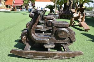 Holzbänke in Motorradform für Reisende im Tempel, Thailand. foto