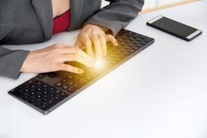 Geschäftsfrau, die Informationen über eine drahtlose Tastatur eingibt foto