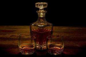 Whisky in zerbrochenen Gläsern mit Karaffe foto