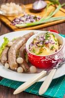 Wiener Würstchen mit Kartoffelsalat und eingelegten Zwiebeln foto