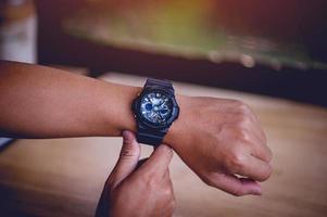 Hände und schwarze Herrenarmbanduhren, Pünktlichkeitskonzepte foto