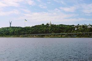kiew, ukraine, 2020 - stadtbild aus dem wasser des mutterlanddenkmals und kiew-pechersk lavra auf grünen fersen. foto