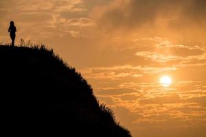 Frauen stehen auf dem Gipfel des Berges mit wunderschönem Sonnenaufgang. im phu chi fah nationalpark in der thailändischen provinz chiang rai. foto