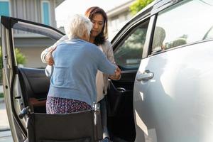 asiatische senior oder ältere alte damenpatientin, die im rollstuhl sitzt, bereiten sich auf ihr auto vor, gesundes starkes medizinisches konzept. foto