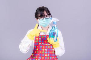 asiatische frauen müssen masken verwenden, um eine staubbelastung und eine infektion durch viren zu verhindern, die sich in der luft ausbreiten, indem sie mit alkoholspray gereinigt werden