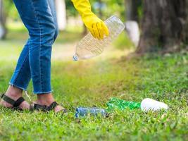 Freiwillige Frauen sammeln im Parkbereich Plastikwasserflaschen von Menschen, die sich weigern, den Müll zu entsorgen foto