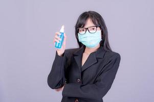 asiatische frauen müssen masken verwenden, um sich vor staubverschmutzung zu schützen und die infektion durch viren zu verhindern, die sich in der luft mit der einführung von vorbeugendem alkoholspray ausbreiten foto
