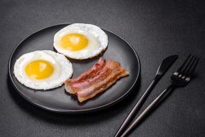 englisches frühstück mit spiegeleiern, speck, bohnen, tomaten, gewürzen und kräutern foto