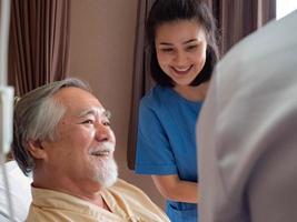 krankenhausklinik oder laborpatient auf dem bett männlich asiatisch glückliches lächeln behandlung von arzt wissenschaftler und krankenschwester covid-19 corona virus krankheit gesundheitsversorgung medizinische unterstützung hilfe versicherung
