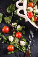 frischer Tomaten-Mozzarella-Salat auf schwarzem Schiefer foto