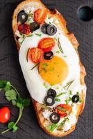 geröstetes Brot Toast mit Spiegeleiern mit gelbem Eigelb und Tomaten, vertikal, Draufsicht, Nahaufnahme foto