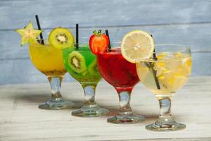 verschiedene alkoholische Cocktails auf weißem Hintergrund. bunte cocktails hautnah. Cocktailgetränk aus Fruchtsaft. verschiedene Cocktailgetränke. Gläser Fruchtgetränke mit Eiswürfeln auf dem Tisch im Café foto