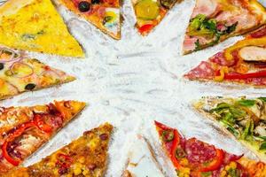 verschiedene Pizzastücke mit verschiedenen Belägen auf weißem Hintergrund. in scheiben geschnitten leckere frische pizza. leckere pizza auf weiß. foto