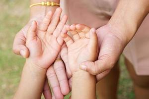 Die Hand der Mutter, die die Hand eines kleinen Mädchens auf Bokeh-Hintergrund hält. Liebes- und Familienkonzept. foto