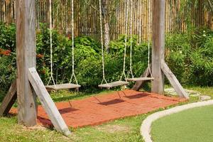 Holzschaukeln auf dem Spielplatz foto