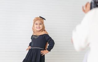 süßes asiatisches muslimisches kleines Mädchen, das ein Foto vom Fotografen macht