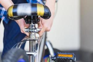 Selektive Fokussierung von Fahrrad-, mechanischen Hobby- und Reparaturkonzepten für Jungen mit der Hand. foto
