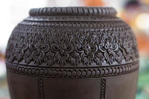 Handgefertigtes geschnitztes Tongefäß aus Ton, das traditionelles thailändisches Steingut ist. foto