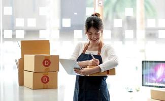 Porträt der Gründung kleiner Unternehmen KMU-Besitzer Unternehmerinnen, die an der Quittungsbox arbeiten und Online-Bestellungen überprüfen, um sich auf das Verpacken der Kartons vorzubereiten, an Kunden zu verkaufen, KMU-Geschäftsideen online zu verkaufen. foto