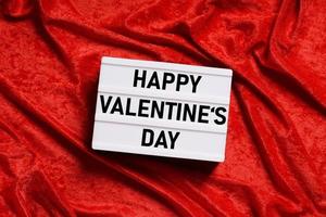 Happy Valentines Day Lightbox auf rotem Samthintergrund foto