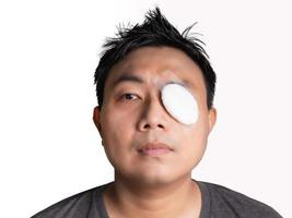 asiatische Männer tragen nach einer Behandlung oder Operation Augenbinden aus Gaze, Sonnenschutz, Staubschutz, Masken, was zu einer verminderten Sicht auch bei kleinen Löchern führt. an einem kühlen, trockenen Ort aufbewahren