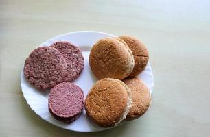 hausgemachte Zubereitung eines gegrillten Burgers mit Tomaten und Salat auf einem Teller foto