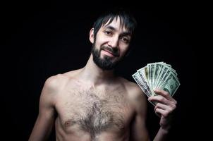 junger Mann mit Banknoten auf schwarzem Hintergrund foto