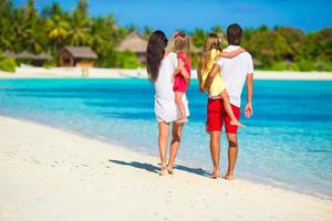 glücklicher schöner Familienurlaub am weißen Strand foto