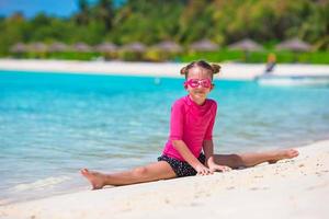 entzückendes kleines Mädchen am Strand während der Sommerferien foto