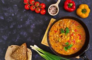 Eintopf mit Fleisch und Gemüse in Tomatensauce auf dunklem Hintergrund foto