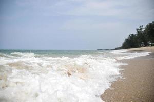 Weitwinkelaufnahme von Meerwasser, das auf den Strand trifft, weißer Schwamm des Meeres, Sommernatur-Hintergrundbildkonzept. foto