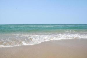 Weitwinkelaufnahme von Meerwasser, das auf den Strand trifft, weißer Schwamm des Meeres, Sommernatur-Hintergrundbildkonzept. foto