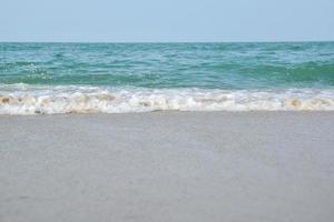 Weitwinkelaufnahme von Meerwasser, das auf den Strand trifft, weißer Schwamm des Meeres, Sommernatur-Hintergrundbildkonzept. foto