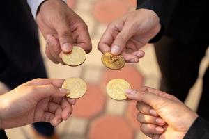 Gruppe von Geschäftsleuten mit Bitcoins in der Hand foto