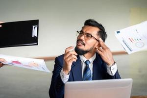 Diese Fristen machen mich fertig. das Bild eines jungen Geschäftsmannes sitzt ängstlich an seinem Schreibtisch im Büro. foto