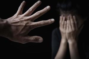 Männerhände verletzen Frauen. Frauen beugen ihre Köpfe und bedecken ihre Hände. Konzept der sexuellen Belästigung, Menschenhandel, Vergewaltigung in der Familie. Belästigung der Wehrlosen. Internationaler Frauentag. foto